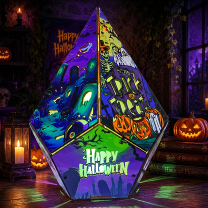 A pyramid-shaped LED light with a colorful Halloween-themed graphic print, glowing with purple, green, and orange hues in a spooky room setting with pumpkins and candles.