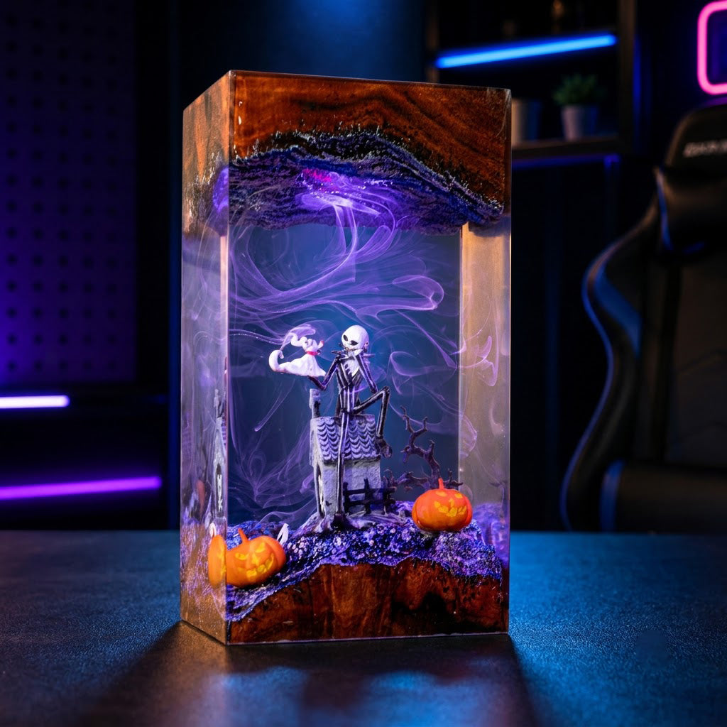 A rectangular resin keepsake box with a Halloween theme, featuring a skeleton figure sitting in a chair, purple smoke effects, two small orange pumpkins, and a purple and brown agate-patterned top, displayed on a dark table with neon-lit background.